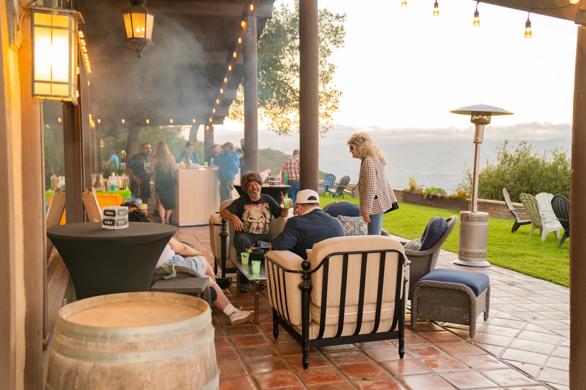 Guests relaxing on a lounge patio at dusk during a hilltop celebration