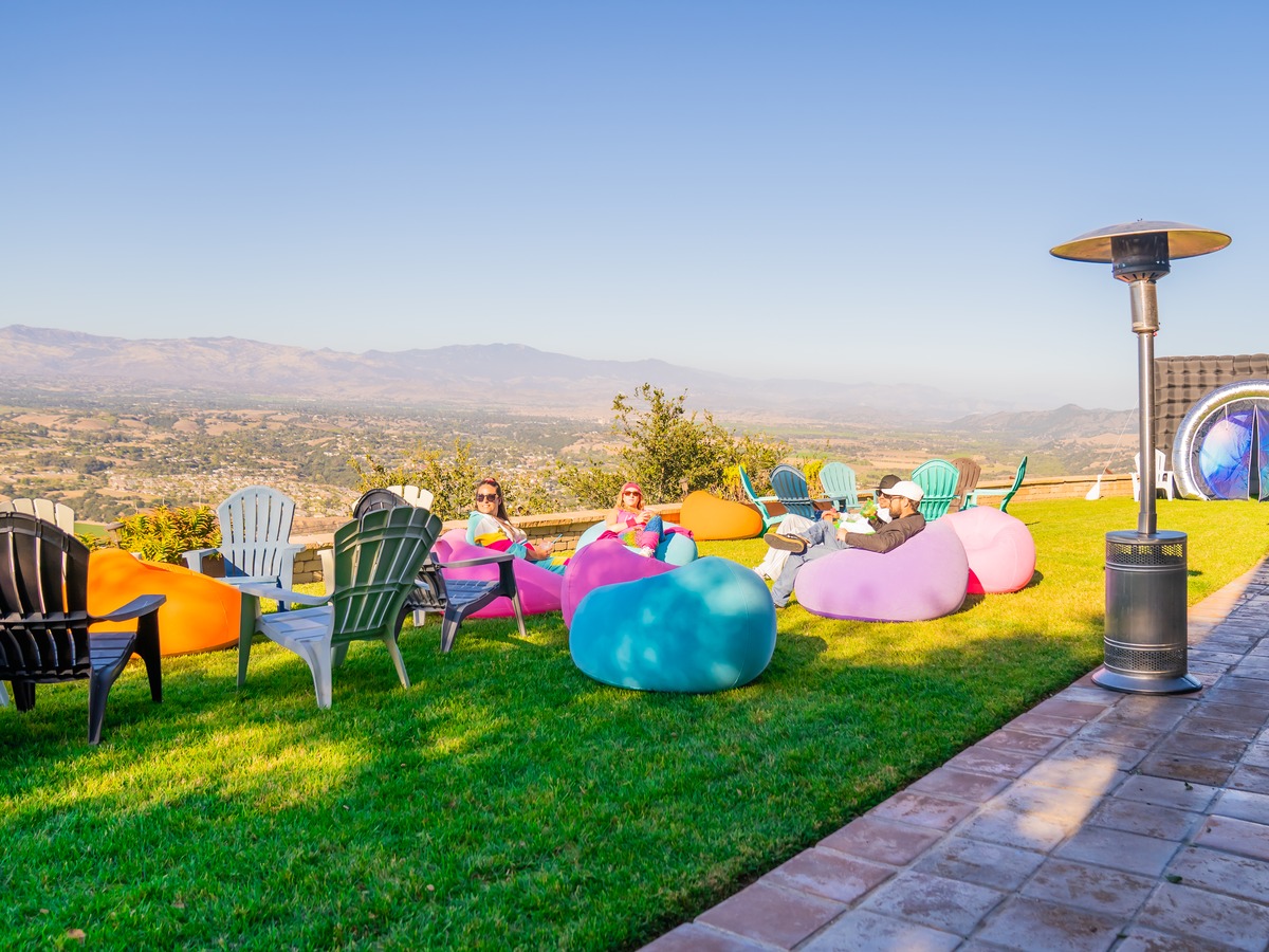 Lounge chairs and bean bags on a hilltop lawn overlooking the valley at golden hour